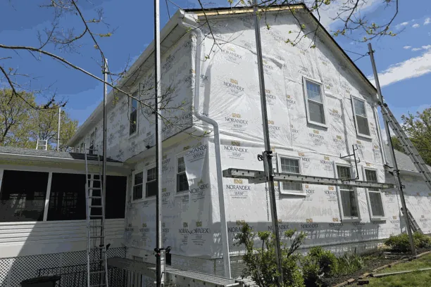 Fiber-cement siding being installed over housewrap