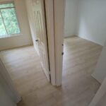 Bedroom remodeling project with fresh paint and wood flooring.