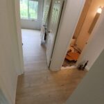 Hallway flooring renovation leading to updated bathroom entrance in maryland