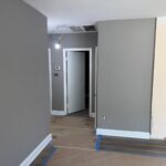 Interior wall and trim painting project with modern gray tones.