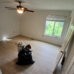 Master bedroom remodel with light oak flooring and fresh wall paint.