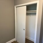 White sliding closet doors installed in renovated bedroom.