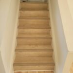 Custom wood stair treads installation with natural finish and white risers.